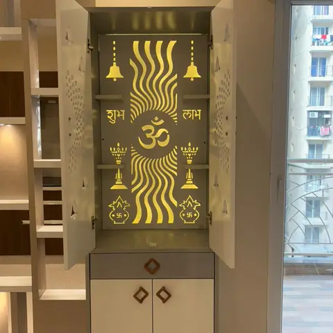 Compact wall-mounted pooja cabinet with a backlit laser-cut Om and Shubh-Labh motif panel and jaali-pattern side doors, over a small storage base.