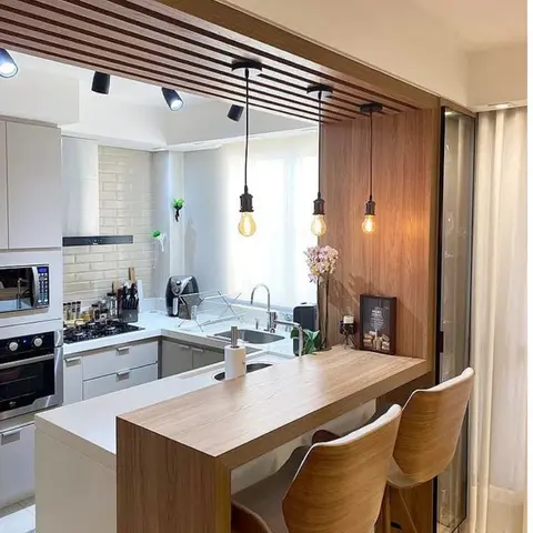 Compact white kitchen with subway tile backsplash and a wood breakfast bar counter with two bentwood stools beneath a wood-slat ceiling strip hung