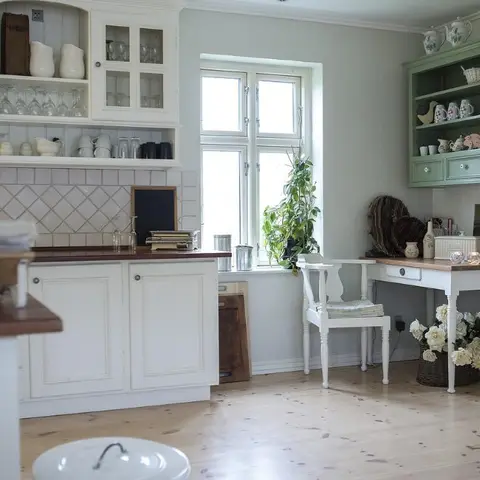 Country-style kitchen with cream shaker cabinetry, a diamond-pattern tile backsplash, a wood countertop