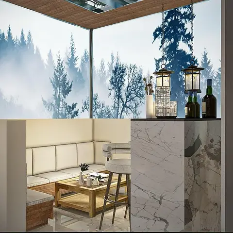 Covered rooftop terrace lounge with a glass-walled sectional seating nook and a marble bar counter overlooking misty pine trees