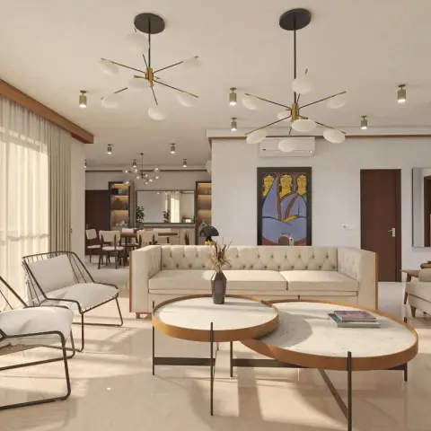 Cream button-tufted three-seater and two black wire-frame lounge chairs set around a pair of overlapping round marble-top tables with timber edges