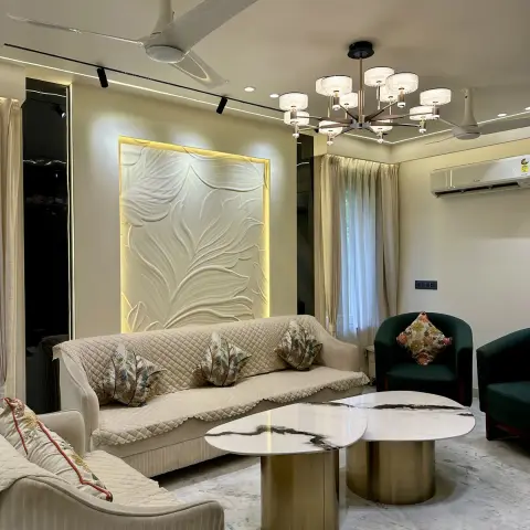 Cream living room with a backlit carved leaf-relief panel behind a quilted-cover sofa