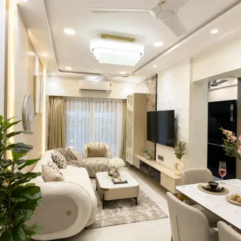 Cream open-plan living zone where an oval crystal drum chandelier hangs beside the ceiling fan