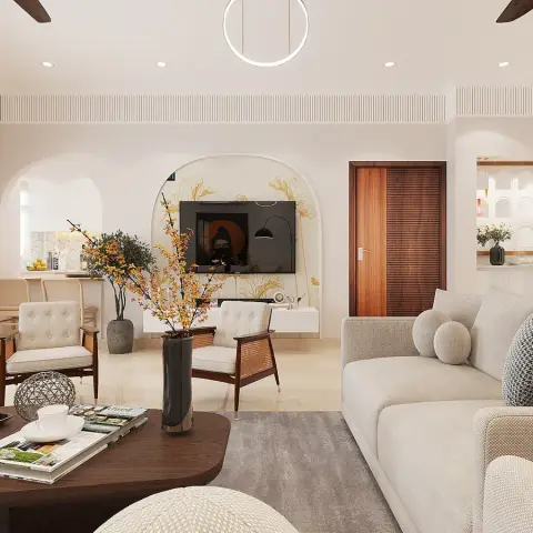 Cream sectional living room where an arched niche holds the TV against gold floral wall art, flanked by cane-back armchairs