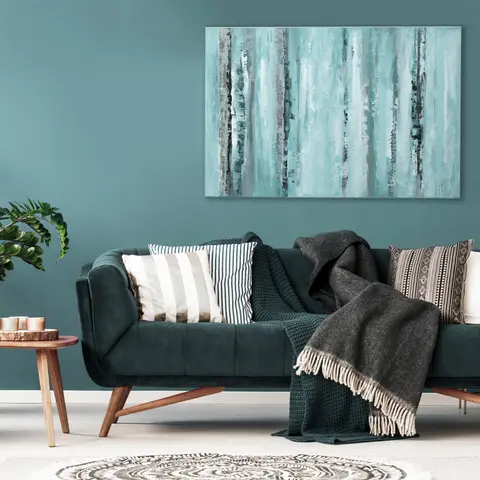 Dark teal velvet sofa with mixed cushions and a chunky knit throw against a matching teal wall hung with a large abstract canvas