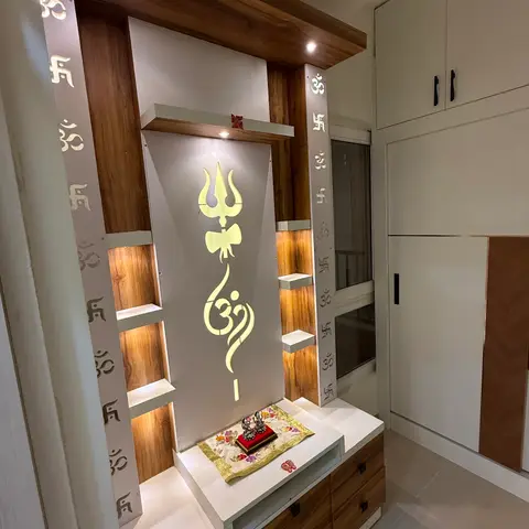 Dedicated pooja unit with a backlit Om and trishul motif panel, laser-cut Om/swastik pillars, open wood-lined niches for idols