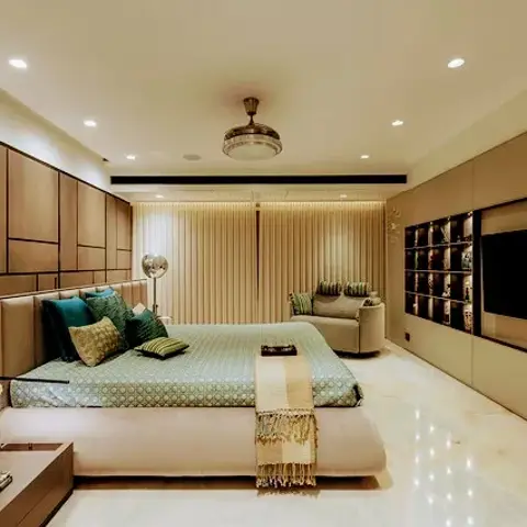 Deep master bedroom with a grid of beige upholstered panels wrapping the side wall, a backlit fluted screen behind the teal-cushioned platform bed