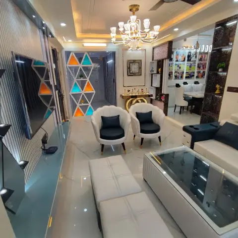 Densely finished living room with a white fluted TV wall inset with black mirror shelves, a triangular lattice display unit lit in orange and teal