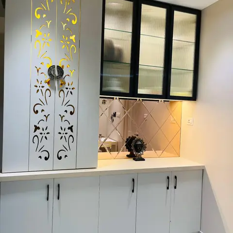 Dining-area crockery unit with a backlit gold floral CNC-cut cabinet door, fluted-glass display cabinets and a diamond-pattern mirrored backsplash.