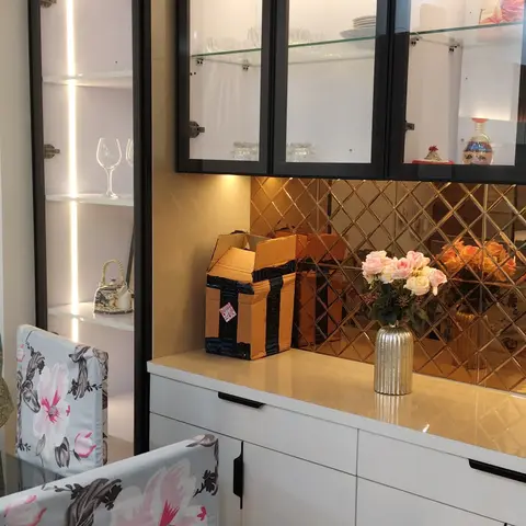 Dining-area crockery unit with black-framed, LED-lit glass display cabinets, a gold diamond mirror-tile backsplash