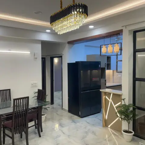 Dining area with a black-and-gold crystal chandelier over a glass-top dining table on glossy marble flooring