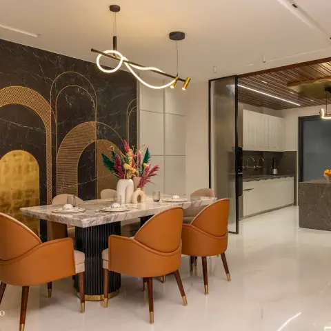 Dining area with a black marble and brass arch-pattern feature wall, a marble-top dining table and tan leather bucket chairs