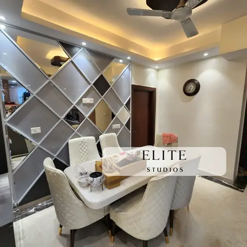 Dining area with a diamond-lattice mirrored feature wall behind a marble-top table and cream quilted-back chairs