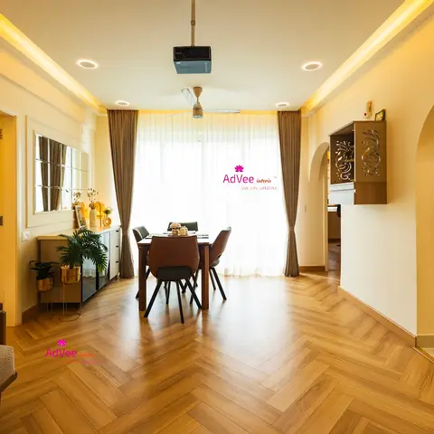 Dining area with a herringbone-pattern wood floor, a four-seat dining table, and an arched opening to the kitchen with a small wall-mounted display niche.
