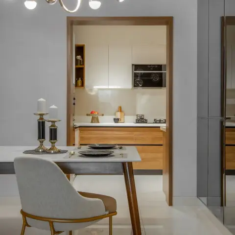 Dining corner against a soft grey wall with a white-top table on tapered walnut legs