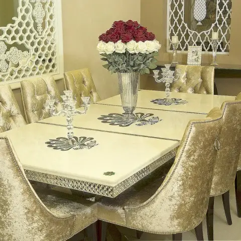 Dining corner with a cream marble-top eight-seater inlaid with dark scroll motifs on a silver-clad apron