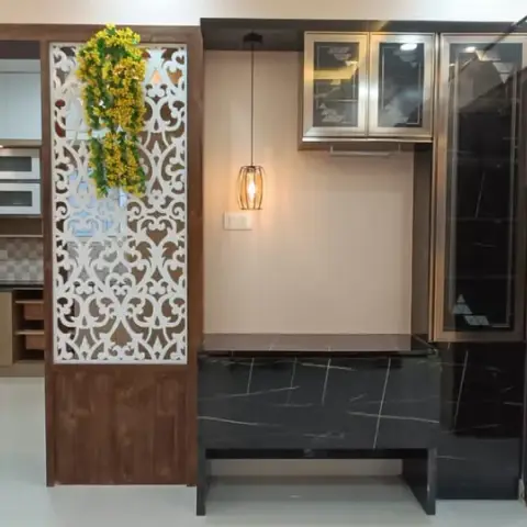 Dining nook with a black marble-topped table and tucked-in bench under a champagne-framed glass crockery unit