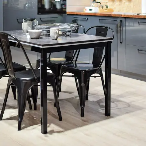 Dining nook with a black metal table and four industrial Tolix-style chairs set against a grey gloss modular kitchen run.