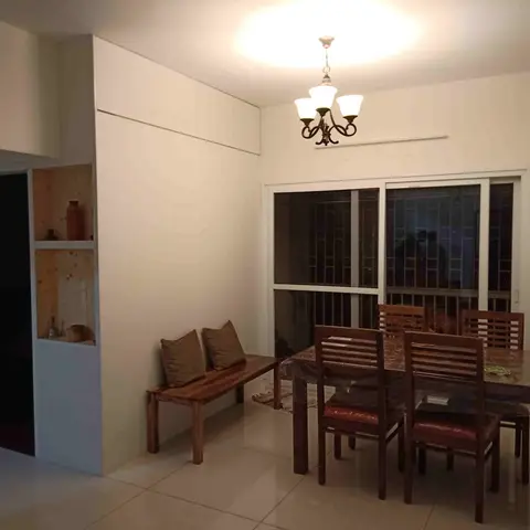 Dining nook with a sheesham wood table and chairs still wrapped in packaging plastic, a cushioned bench along the wall