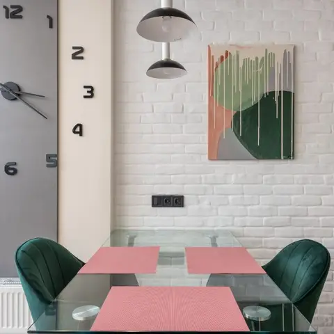 Dining nook with an oversized numeral wall-clock feature, exposed white-brick wall and two drip-painted abstract canvases