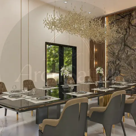 Dining room seating twelve at a long glass-top table beneath a gold branch chandelier, with a dramatic natural stone feature wall behind.