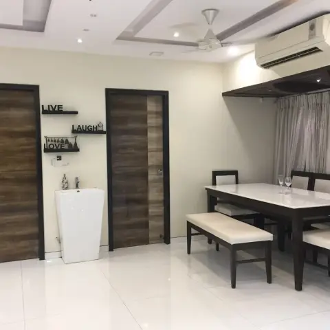 Dining room with a dark wood table, upholstered bench and chairs, a coffered cove-lit ceiling and a pedestal wash basin styled with a 'Live Laugh Love' decor