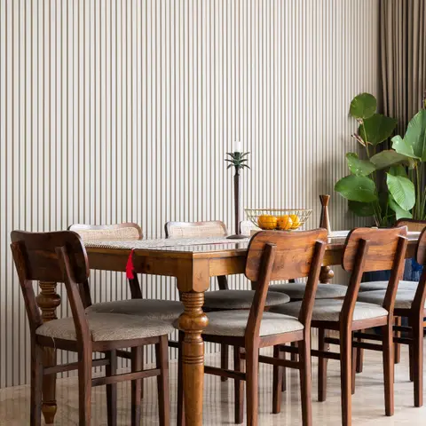 Dining room with a fluted vertical panel accent wall, a wood ceiling, a turned-leg wood dining table seating eight in a mix of cane-back and solid wood chairs