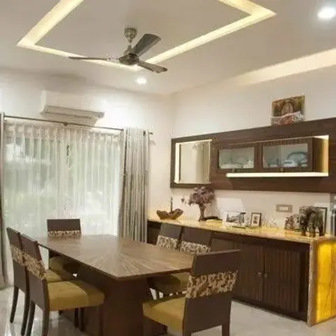 Dining room with a square cove-lit ceiling design, a dark wood dining table with yellow-cushioned chairs