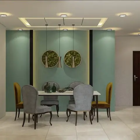 Dining room with a teal textured accent wall, twin moss wall-art discs, pendant lights under a cove ceiling, and a black glass-front crockery unit.