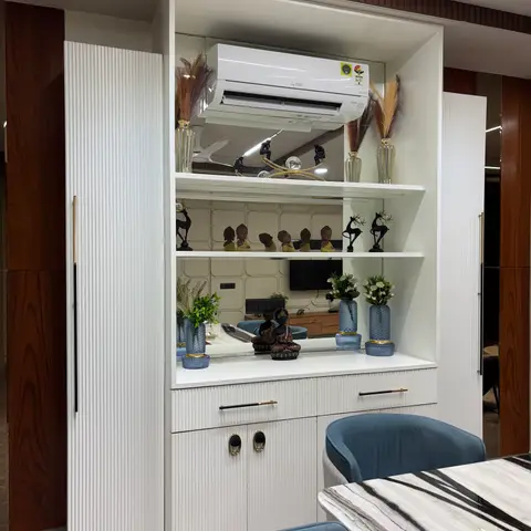 Dining room with a white fluted crockery unit housing a curated display of vases, figurines and a mirrored backsplash