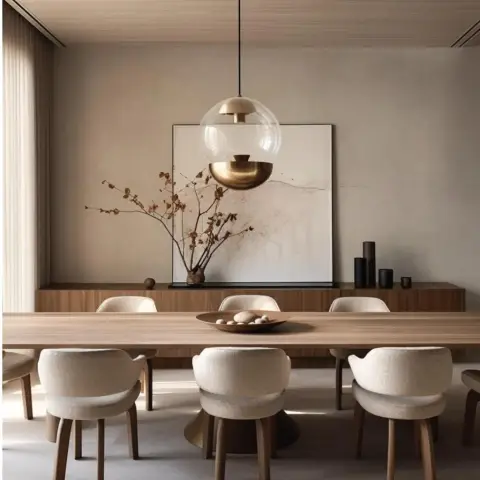 Dining room with a wood table, boucle upholstered chairs, a brass and glass globe pendant light, and a styled console with a large abstract art piece.