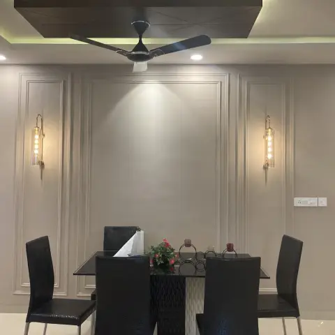 Dining set against a greige wall divided into three applied moulding panels, a brass-and-glass tube sconce lighting each outer panel