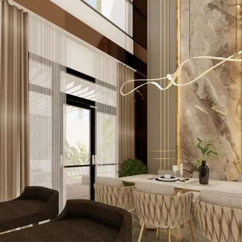 Double-height dining nook with a sculptural ribbon pendant light over a marble table, backed by a gold-inlaid marble accent wall