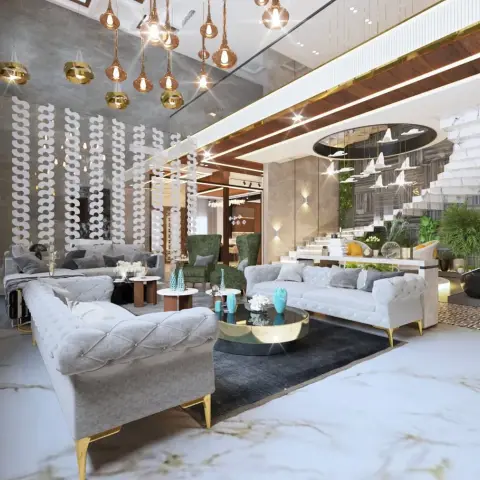 Double-height living hall with button-tufted grey sofas on gold legs, emerald wing chairs