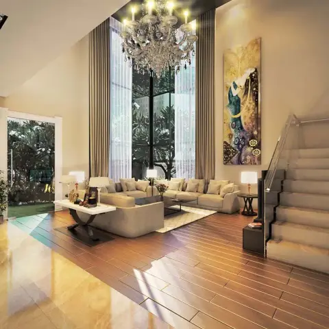 Double-height living room where a tiered crystal chandelier hangs past two-storey corner glazing onto an L-shaped beige sofa