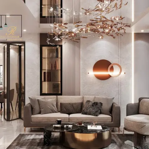 Double-height living room where a cascading amber-glass leaf chandelier hangs over a taupe sofa