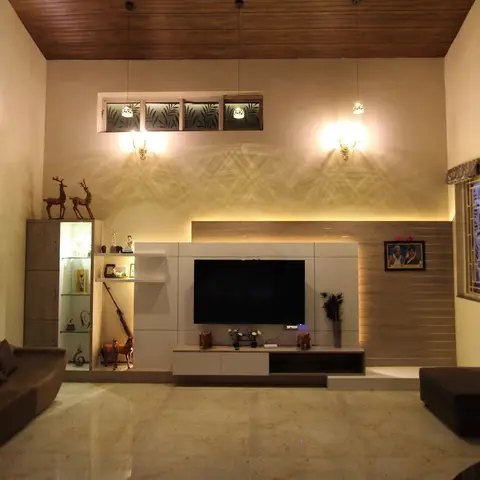 Double-height living room with a wood-clad angled ceiling, a backlit TV feature wall in stone cladding, curio display shelving with figurines