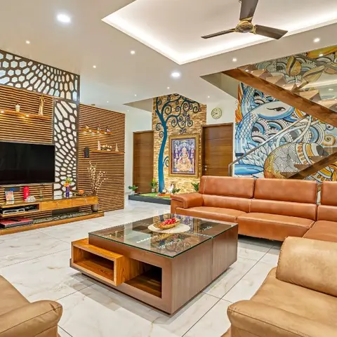 Double-height living room with a backlit laser-cut wood jaali TV wall, tan leather sectional sofas, a wood-and-glass coffee table with open cubbies