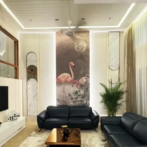 Double-height living room with a floor-to-ceiling flamingo mural flanked by backlit ivory panels