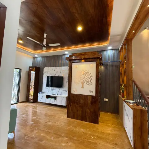 Double-height villa living room with a walnut-grain laminate ceiling raft over a cove-lit reveal, a marble-clad TV wall on charcoal fluted panelling