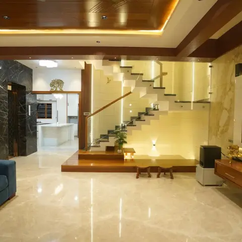 Double-height villa living room with a teak-slat ceiling over cove light, a beige marble TV wall with teak console