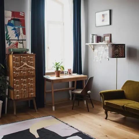 Eclectic living room with an olive-green velvet sofa, a vintage wood library-card cabinet