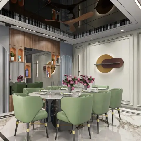 Eight sage-green velvet chairs on brass-tipped black legs around a round white marble table on a black marble pedestal
