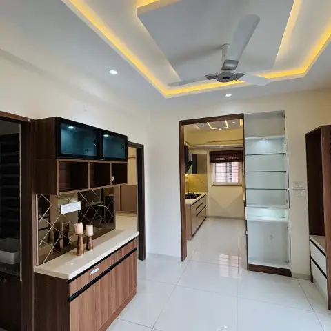 Empty dining zone at handover with a walnut crockery counter under a diamond-bevelled mirror backsplash, a lit glass display niche