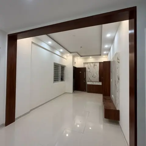 Empty entrance foyer with a dark wood door frame beam, a marble-clad accent wall, and a floating wood console beside the main door
