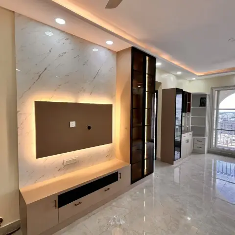 Empty flat living room at handover with a backlit taupe TV panel on a marble-look slab wall over floating drawers