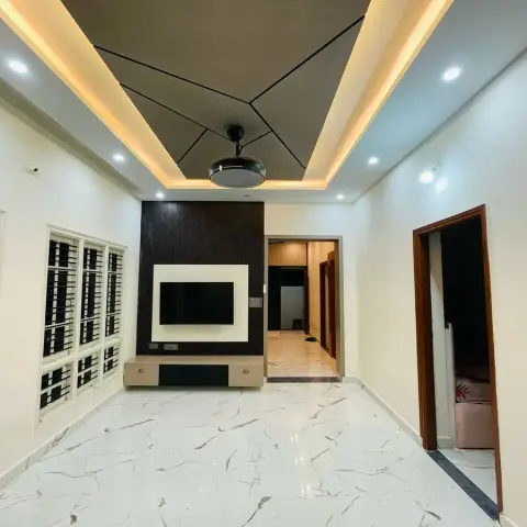 Empty hall with a dark wood-grain TV panel framed in white gloss above a two-drawer floating console