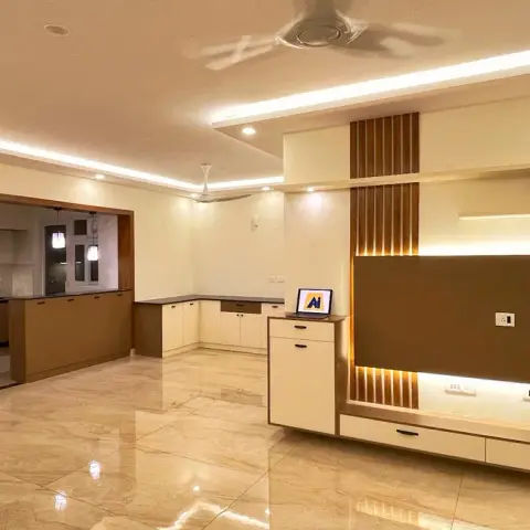 Empty handover shot of a living room with a backlit brown TV panel flanked by fluted battens and lit display niches, a stepped cove-lit POP ceiling