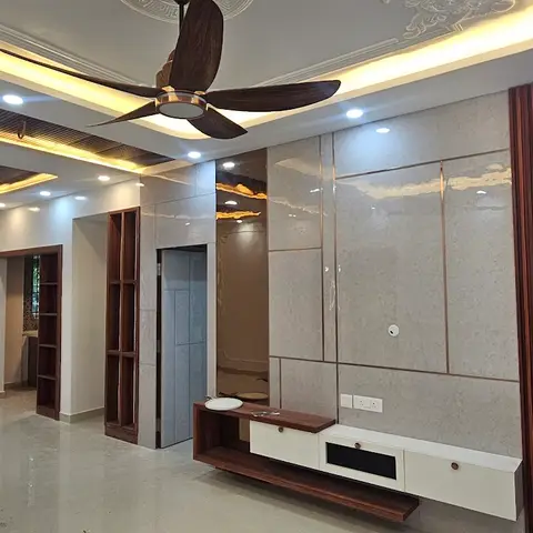 Empty living room mid-handover with an ornate medallion-detailed cove-lit false ceiling, marble-effect glossy TV feature wall bordered by dark wood fluting