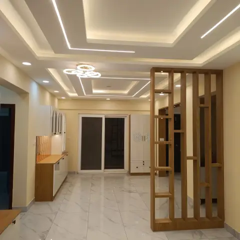 Empty new-flat living-dining hall lit only by its ceiling: stepped POP layers with recessed linear profile lines